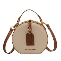 A round crossbody bag in beige with a brown strap and branding, featuring a stylish circular design.