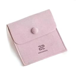 A pink microfiber jewelry pouch with a snap button closure and a logo on the front.