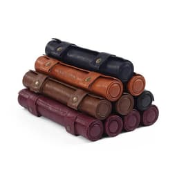 A stack of foldable PU leather scroll dice bags in various colours, featuring buttons and straps for closure.