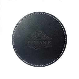 A round black PU leather coaster featuring a decorative embossed design and contrasting white stitching.