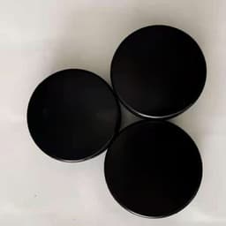 Three black rubber ice hockey pucks arranged in a triangular formation, featuring a logo on each puck.