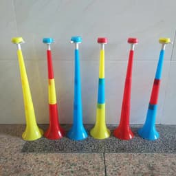A set of plastic retractable stadium horns in red, blue, yellow, and a mix of these colours, arranged in a row.