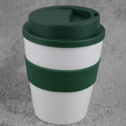 A plastic coffee cup in white with a green silicone sleeve and lid, featuring a logo on the side.