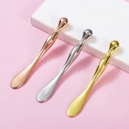A set of three eye roller massage sticks in rose gold, silver, and gold, displayed on a light background.