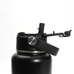 A drink bottle with a black stainless steel body and a handle, featuring a lid with a spout and lever mechanism.