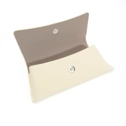 A hard shell eyeglasses case in cream with a soft beige interior, featuring a snap closure.