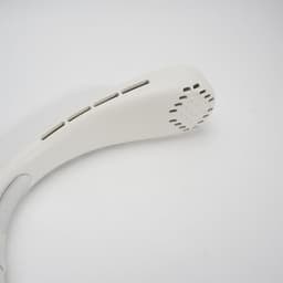 A portable neck fan in white with ventilation holes for airflow. It features a sleek, curved design.