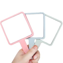 A collection of square-shaped handheld mirrors in pink, blue, and green, being held by a hand.