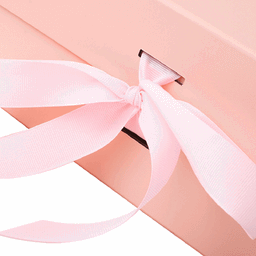 A pink collapsible gift packaging box with a ribbon tied in a bow. It has a logo on the side.