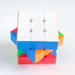 A 3x3x3 magnetic speed cube featuring white, blue, red, green, orange, and yellow colours, with a logo on one side.