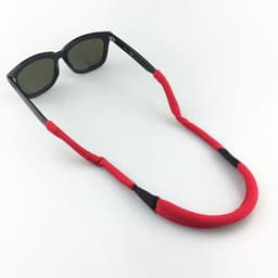 A red eyeglass string holder with black accents, featuring a pair of sunglasses attached.
