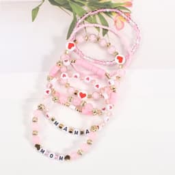 A collection of pink clay bead friendship bracelets featuring hearts and letter beads spelling "MAMA" and "MOM."