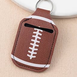 A brown PU leather hand sanitiser holder keychain with a football design and white stitching details.