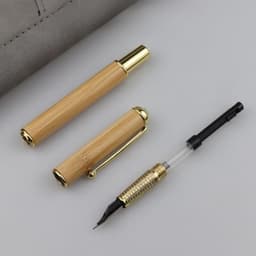 A Natural Bamboo Fountain Pen Gift Set featuring a bamboo pen and a gold-accented pen cap on a grey background.