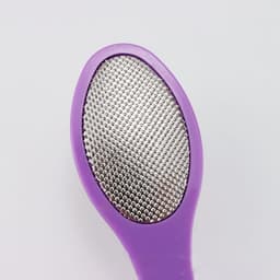 A purple multi-purpose foot file featuring a textured metal surface for smoothing.