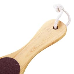 A foot file callus remover with a wooden handle and a dark abrasive surface, featuring a hanging loop.