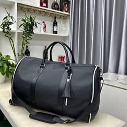 A black wheeled garment bag with a shoe compartment, featuring a zipper and a decorative tassel.