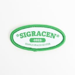 A green and white embroidered patch featuring the text “SIGRACEN 2022” and “SIMPLEGRACECENTER”.