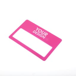 A pink credit card-shaped magnifier with a clear rectangular viewing area. It contains branding.