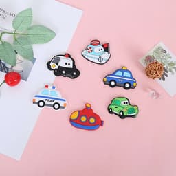 A set of colourful personalised refrigerator magnets featuring various vehicle designs, including police cars, a taxi, and a submarine.