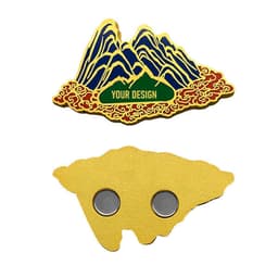 A metal fridge magnet featuring a mountain design in blue and gold, with a green area for customisation.