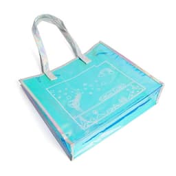 A transparent iridescent handbag in shades of blue with a whimsical design and two handles. It features branding.