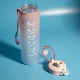 A drink bottle in pink and purple with a time scale, featuring a removable lid and a carrying strap.
