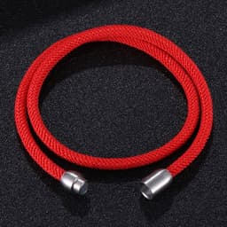 A red double-layer rope bracelet with a magnetic clasp and silver ends, resting on a black surface.
