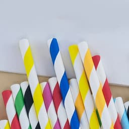 A collection of paper drinking straws in various colours, including stripes of blue, yellow, and red, with a white background.