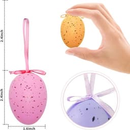 A hand holds an orange speckled Easter egg, alongside a pink speckled egg with a ribbon. Both eggs are for outdoor hanging.