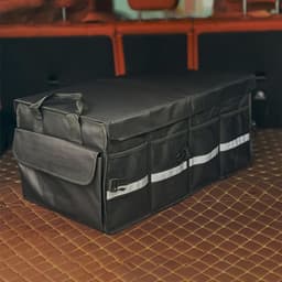 A black multi-compartment car trunk organiser with multiple pockets, placed in a vehicle's boot.