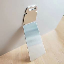 A shiny aluminium photo panel with a handle, showcasing a reflective surface against a wooden background.