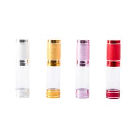 A set of four 15ml airless travel pump bottles in clear, gold, pink, and red with metallic accents.
