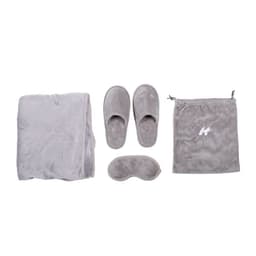A grey travel sleeping kit featuring a blanket, slippers, sleep mask, and a drawstring bag.