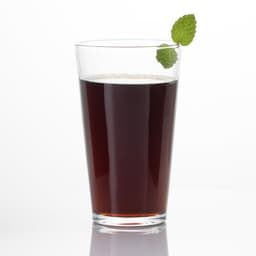 A clear pint glass filled with dark liquid, garnished with a mint leaf on top.