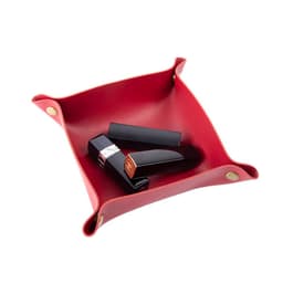 A red foldable leather storage tray with black lipstick tubes inside. The tray features metal corners and branding.
