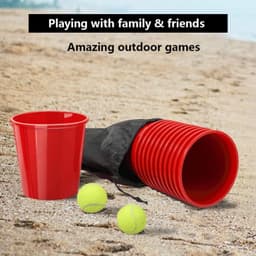 A set of red cups, a black carrying bag, and two yellow balls on a sandy beach.