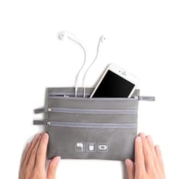 A grey cable organiser storage bag with three zippered pockets, holding earphones and a smartphone.