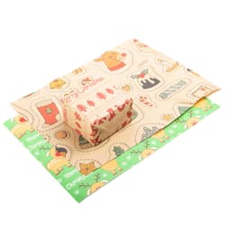 Colourful personalised gift wrapping paper featuring Christmas-themed designs, with a small wrapped gift on top.
