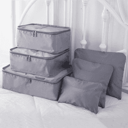 A set of six grey travel storage bags in various sizes, featuring zip closures and a simple design.