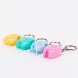 A set of four dental floss dispensers in yellow, blue, green, and pink, each attached to a keychain.