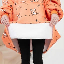 An orange flannel hoodie blanket featuring a corgi design with a soft white lining.
