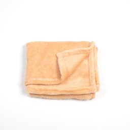 A folded pet flannel fleece blanket in a soft peach colour, featuring a slightly darker edge.