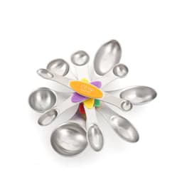 A set of stainless steel coloured double-ended measuring spoons in various sizes arranged in a fan shape, with a central holder.