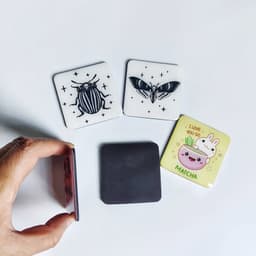 Four epoxy fridge magnets in various designs: insect illustrations, a butterfly, and a cute matcha-themed graphic.