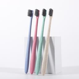 Four eco-friendly wheat straw soft toothbrushes in pastel colours: purple, pink, mint green, and natural beige, displayed together.