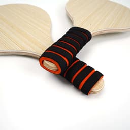 Two wooden beach rackets with black and orange grips, featuring a simple yet elegant design.