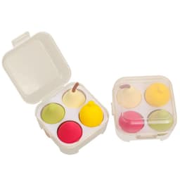 A clear case containing four fruit-shaped beauty sponges in green, yellow, pink, and red.