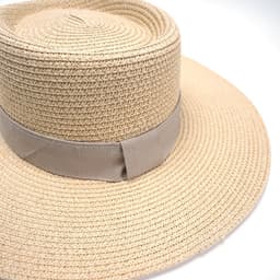 A wide-brimmed Panama straw hat in natural beige with a matching ribbon band.