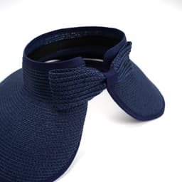 A navy blue foldable wide brim roll-up hat with a bow detail and a flexible design. Features a logo.